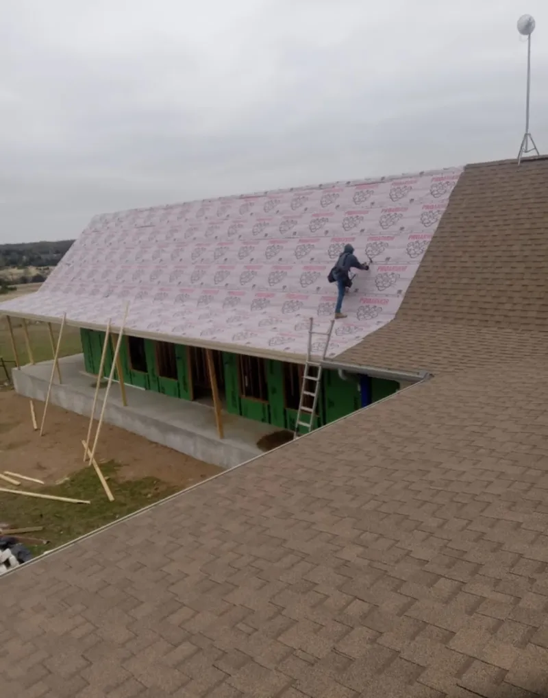 Worker preparing underlayment for a metal roof installation in Mount Pleasant